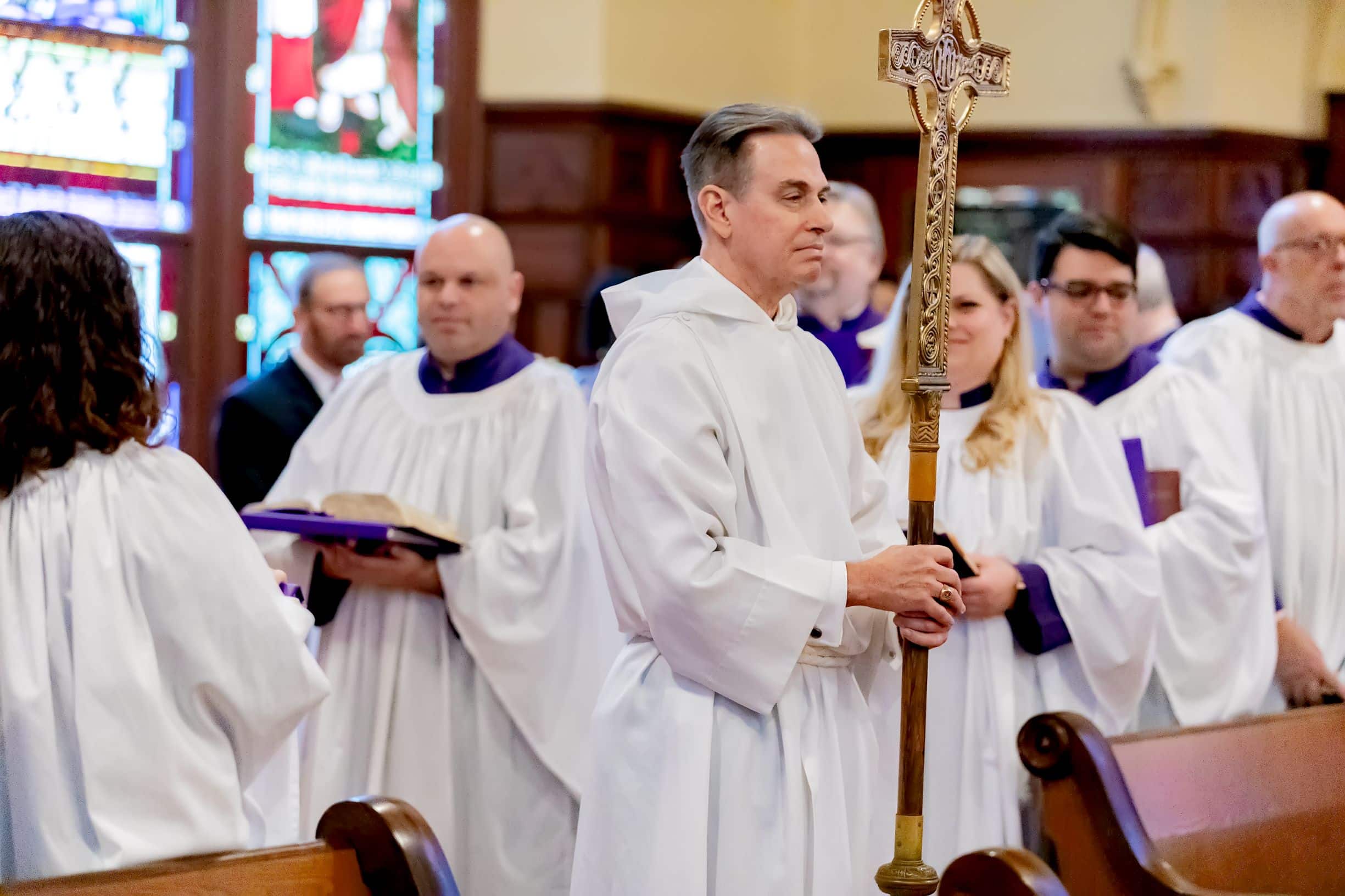 Male choir singer holding crucifer during church service at Christ Church Cathedral in Houston, TX.